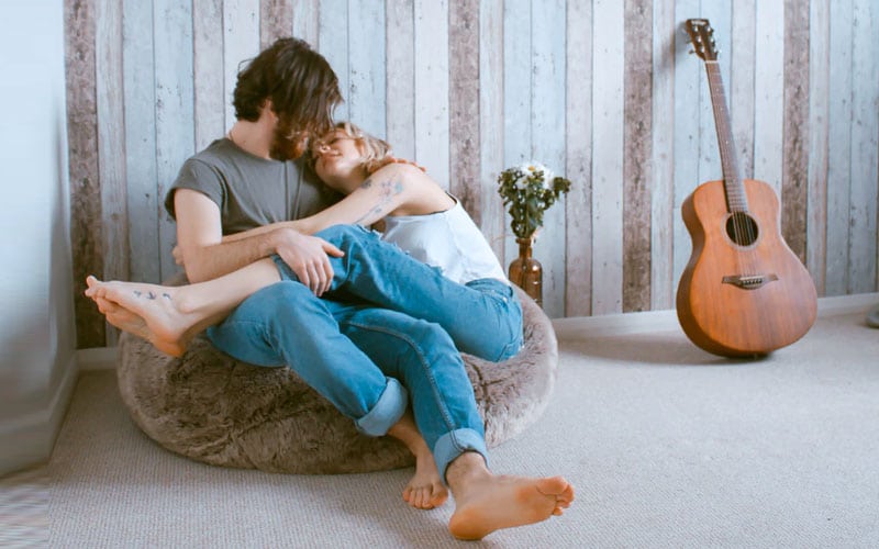 couple romantically entangled on bean bag chair